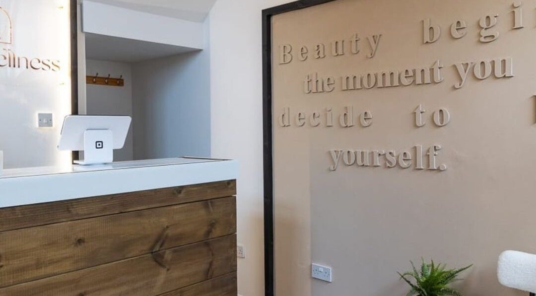Reception area of Gaia Wellness, Berkswell, England, with inspiring wall quote and wooden desk.