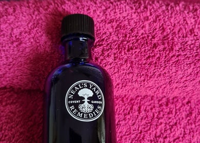 Elegant blue glass bottle on a vibrant pink towel at RENUMI Mind-Body Therapies & Coaching, Musselburgh, Scotland, GB.