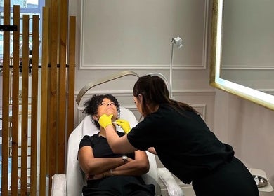 Aesthetician provides facial treatment at Blossom Aesthetics & Skin, Failsworth, England, GB in a relaxing setting.