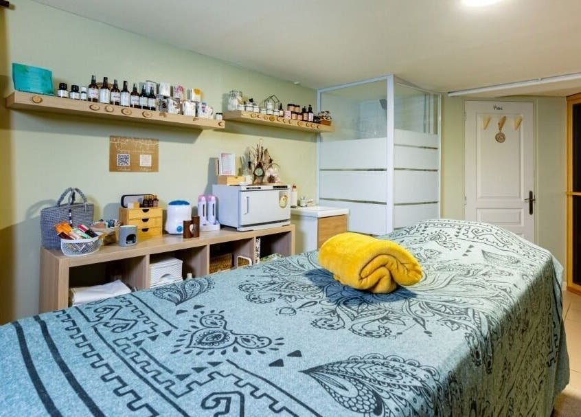 Salle de soins élégante à La beauté d'une plume, Darnétal, Normandie, FR, avec table de massage et décor apaisant.