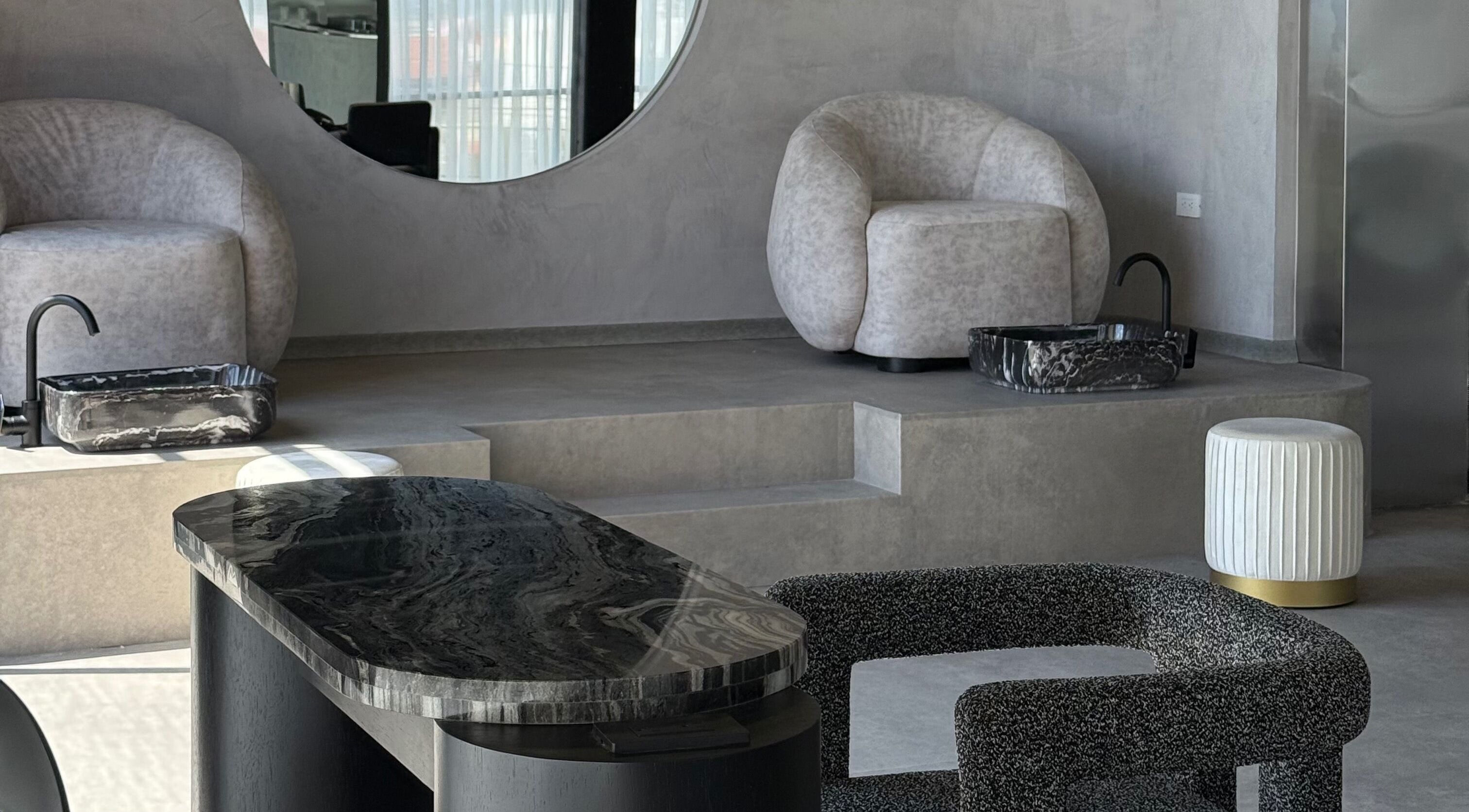 Área de relajación en Zūl Beauty, Quito, Pichincha, EC, con sillas modernas y lavamanos de mármol.