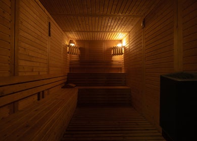 Wooden sauna room at Aurora Spa I أورورا سبا in Riyadh, Riyadh Province, SA with warm ambient lighting.
