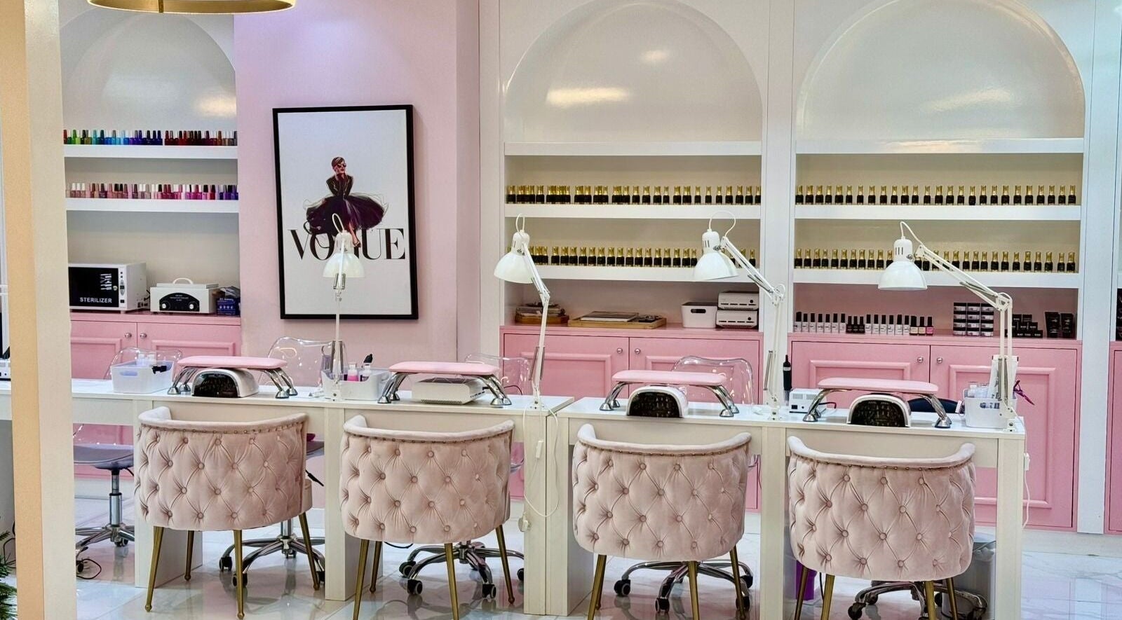 Luxury nail stations at Beauty By Bella Salon in Dubai, Dubai, AE, with pink decor and elegant seating.