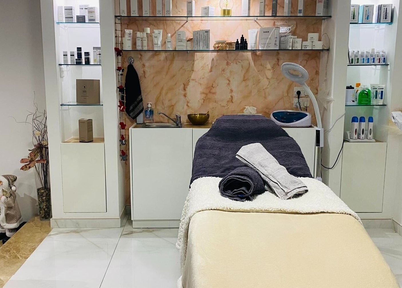 Treatment room at Armonija Med Aesthetics in Ħ'attard, MT, featuring a cozy massage table and elegant decor.