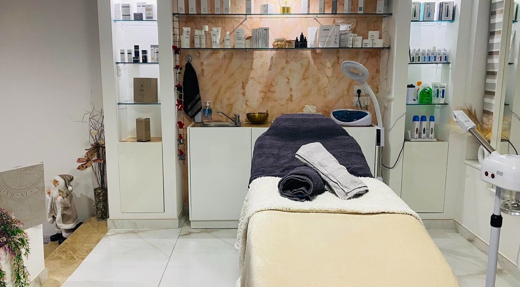 Treatment room at Armonija Med Aesthetics in Ħ'attard, MT, featuring a cozy massage table and elegant decor.