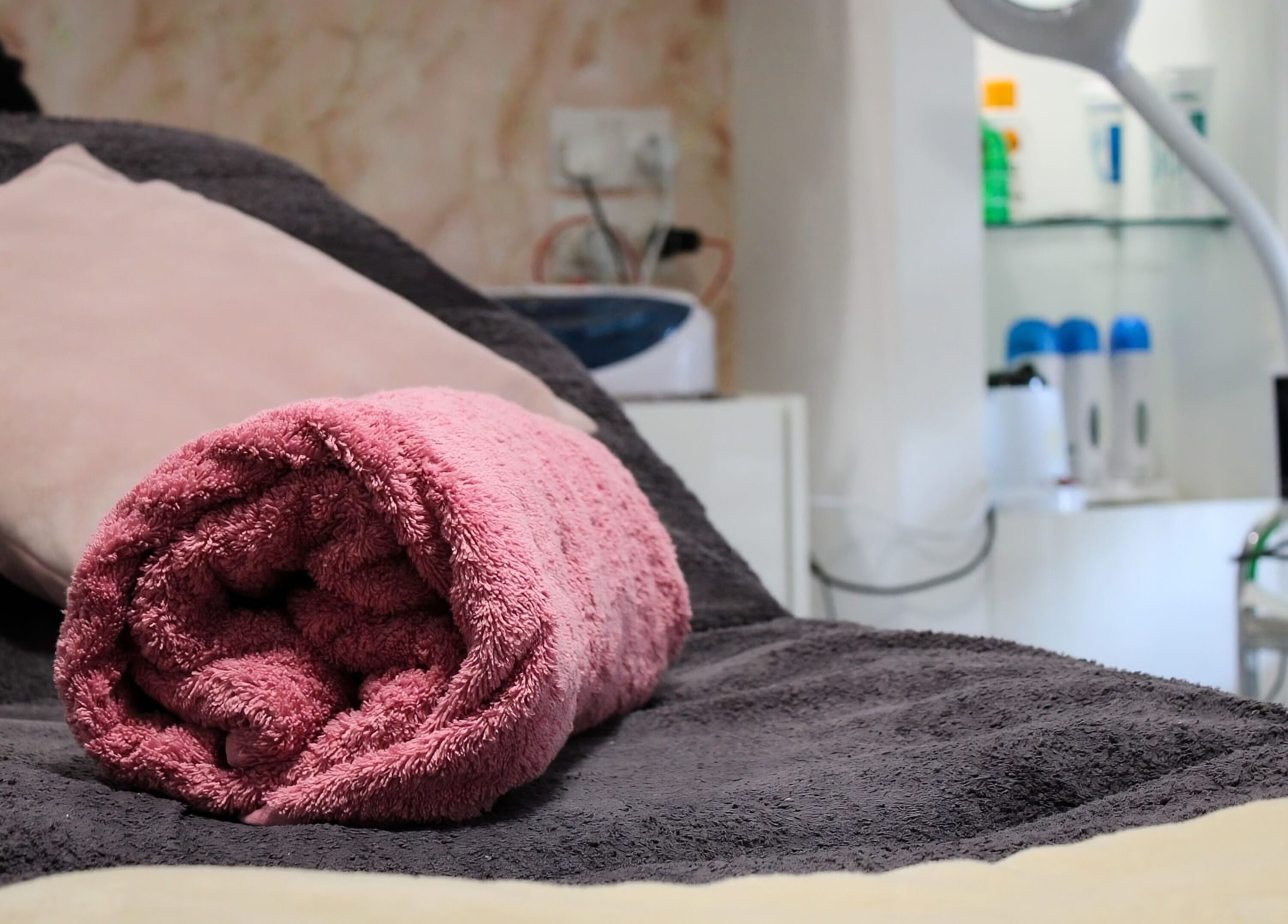 Relaxing spa setting at Armonija Med Aesthetics, Ħ'attard, MT with plush towels and skincare products.