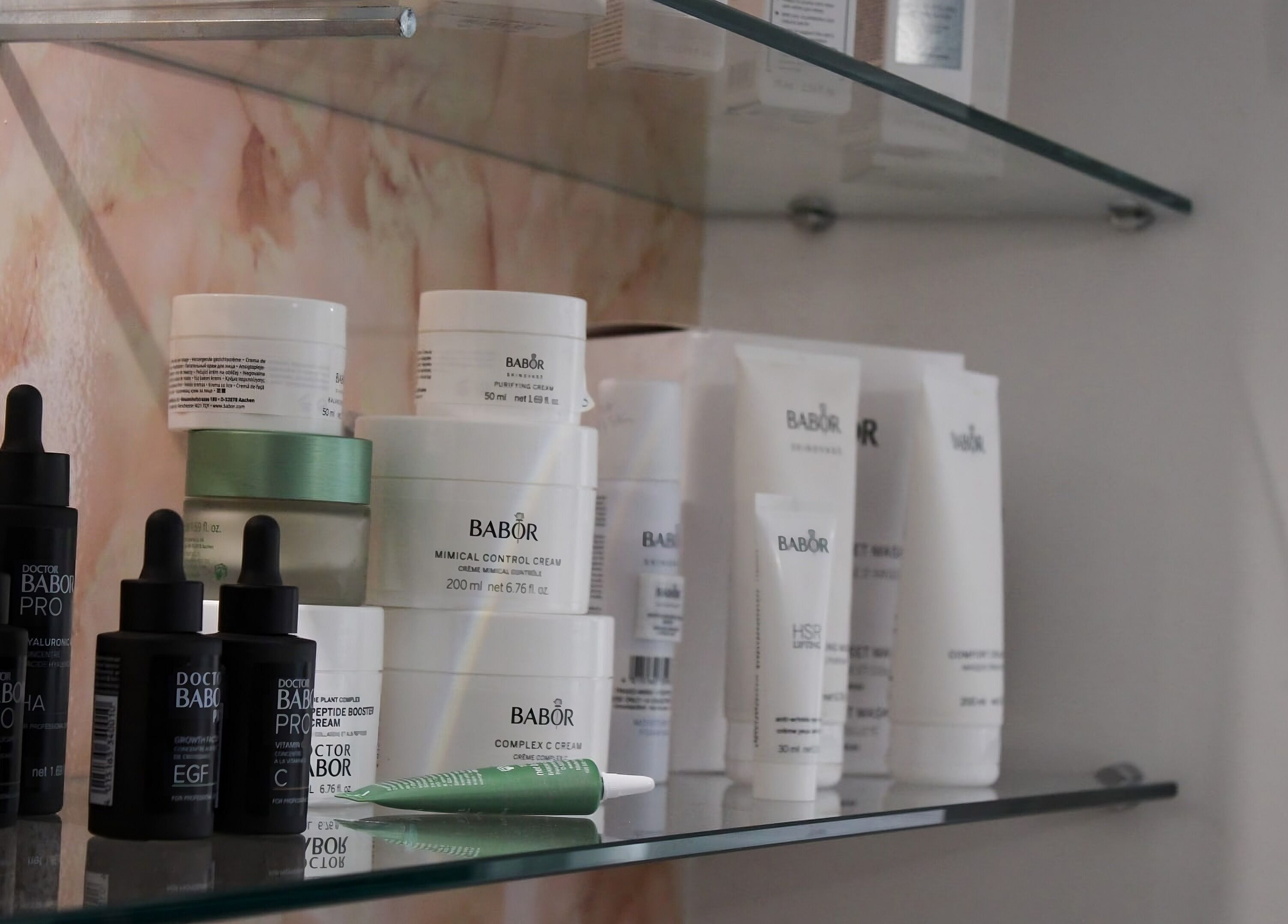 Armonija Med Aesthetics in Ħ'attard, MT showcases premium skincare products on elegant glass shelves.