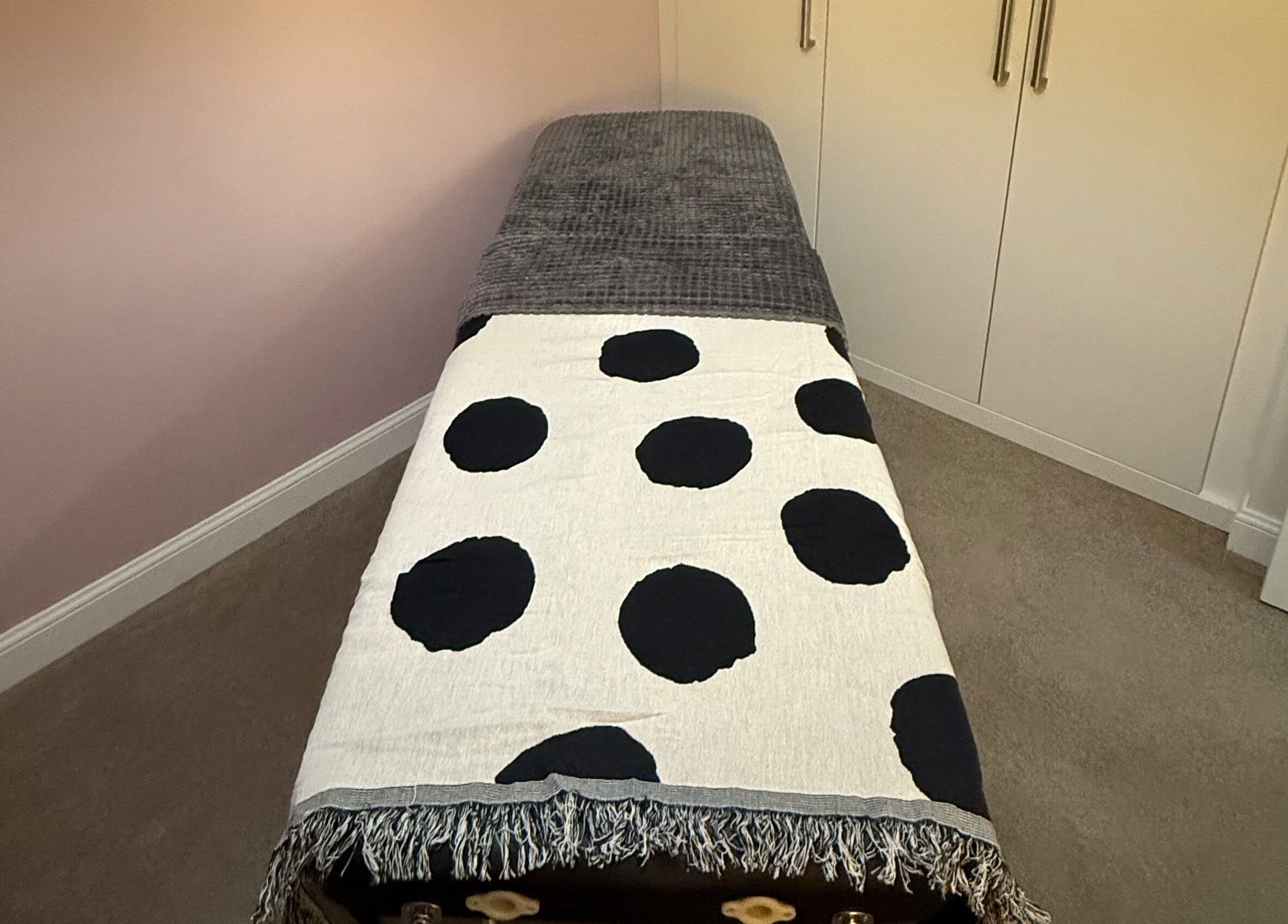 Cozy massage bed with polka dot throw at Essence Beauty in Barnsley, England, GB.