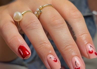 Elegant cherry nail art at Olive Studio, Mansfield, England, GB showcasing red and neutral tones.