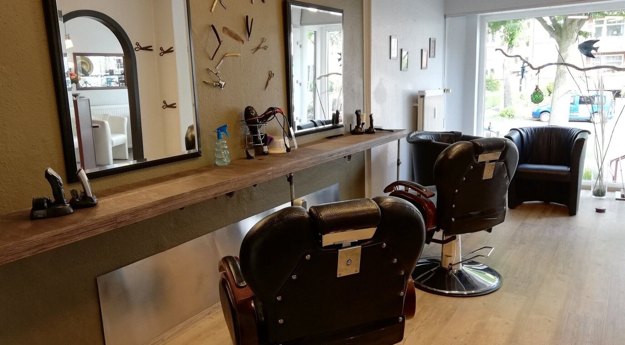 Moderner Salonstuhl und Spiegel bei Salon Martens in Lübeck, Schleswig-Holstein, DE.
