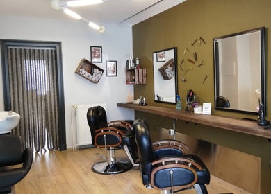 Innenraum von Salon Martens in Lübeck, Schleswig-Holstein, DE mit stilvollen Friseurstühlen und Spiegeln.