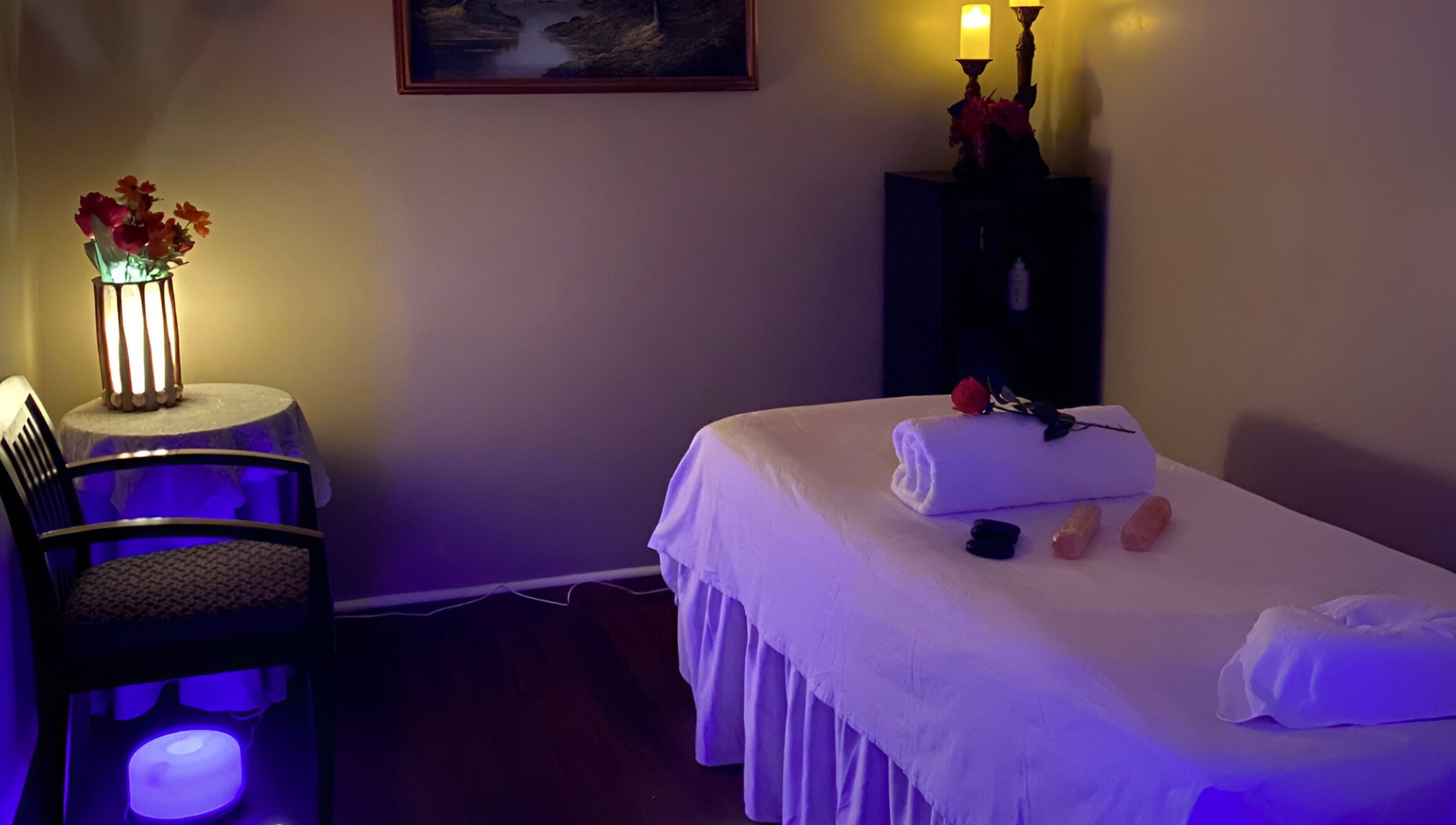Tranquil massage room at Chi Foot Spa, Williamsburg, Virginia, US with ambient lighting and a massage table.