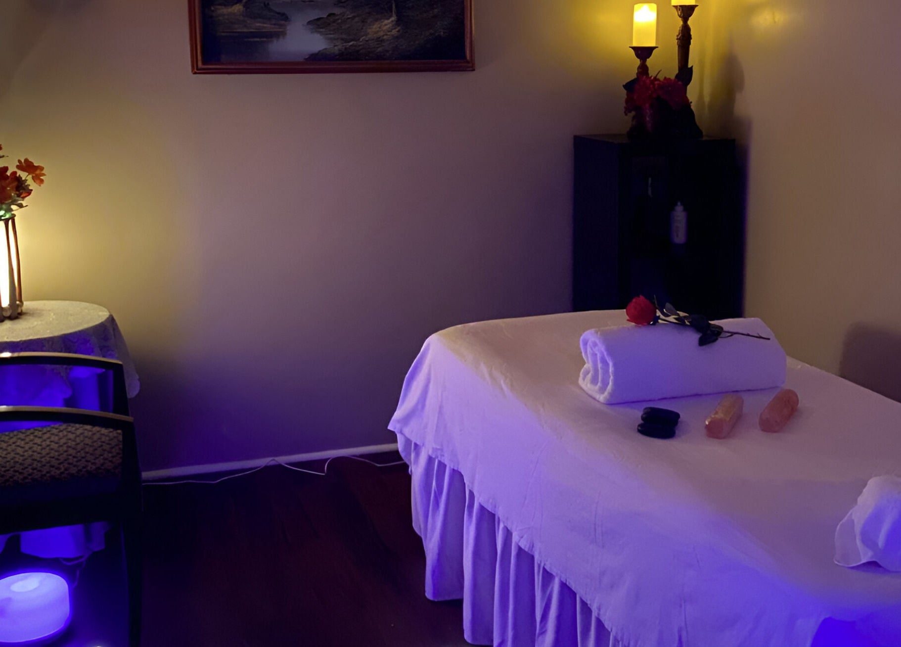 Tranquil massage room at Chi Foot Spa, Williamsburg, Virginia, US with ambient lighting and a massage table.