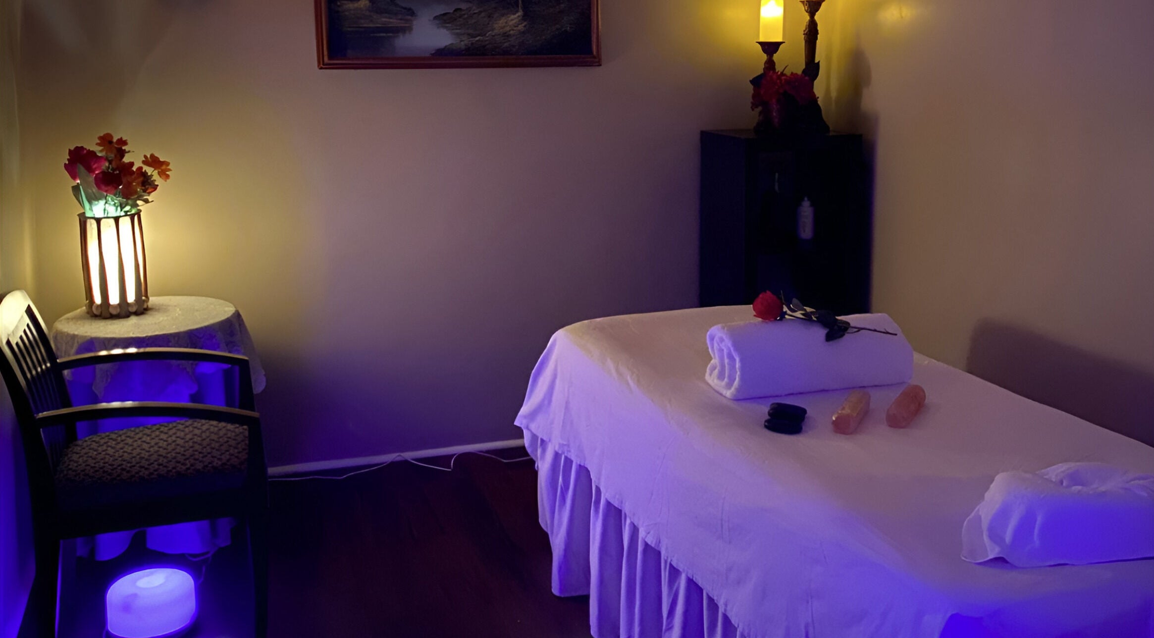 Tranquil massage room at Chi Foot Spa, Williamsburg, Virginia, US with ambient lighting and a massage table.