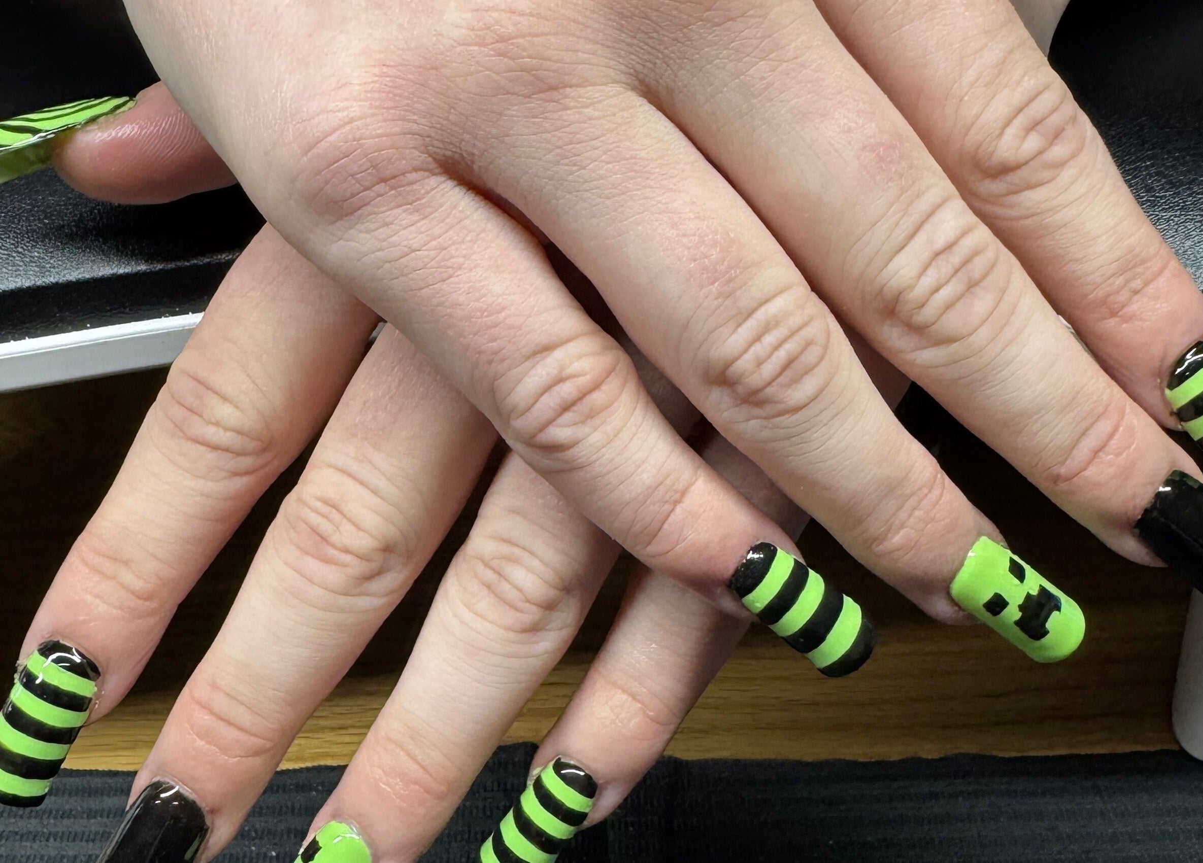 Lime green and black striped nails at Bullet Beauty Bar, Meadow Springs, Western Australia, AU.