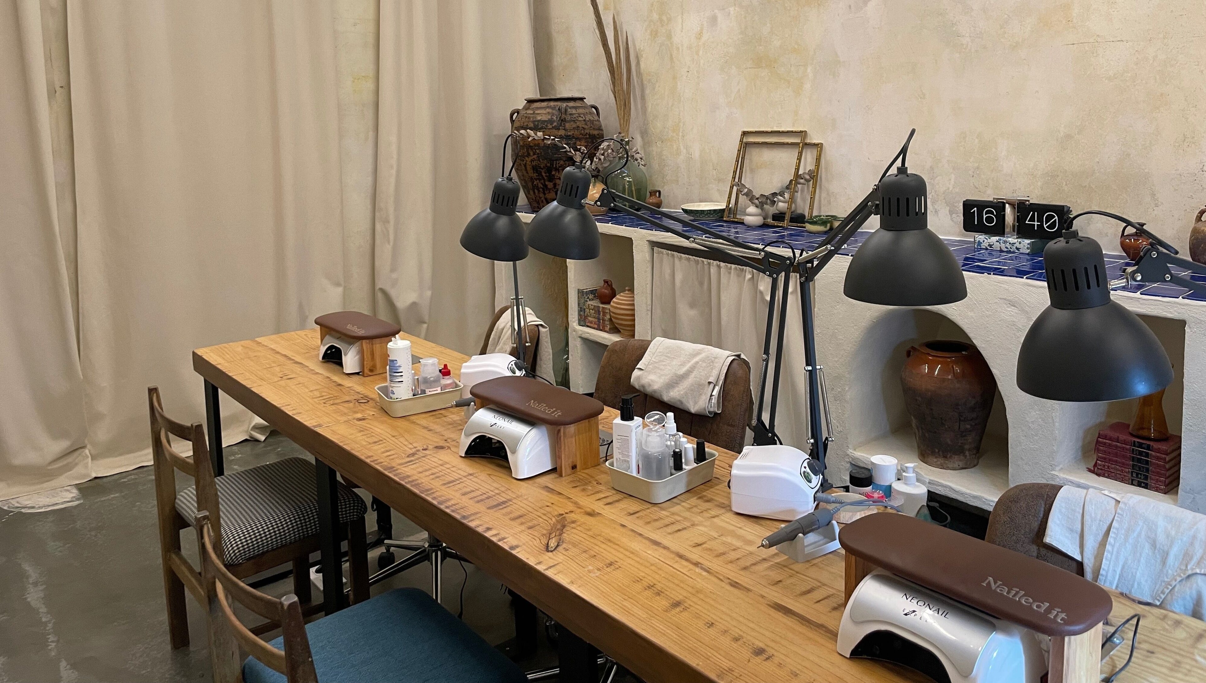 Mesa de manicura elegante en Nailed It!, Barcelona, Catalunya, ES, con lámparas modernas y herramientas de uñas.