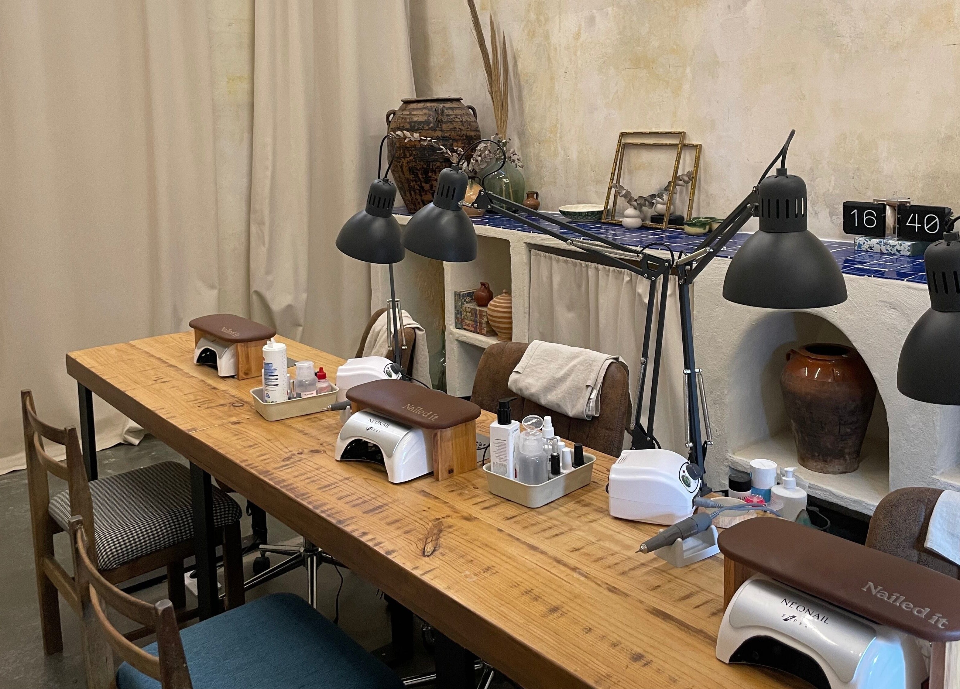 Mesa de manicura elegante en Nailed It!, Barcelona, Catalunya, ES, con lámparas modernas y herramientas de uñas.