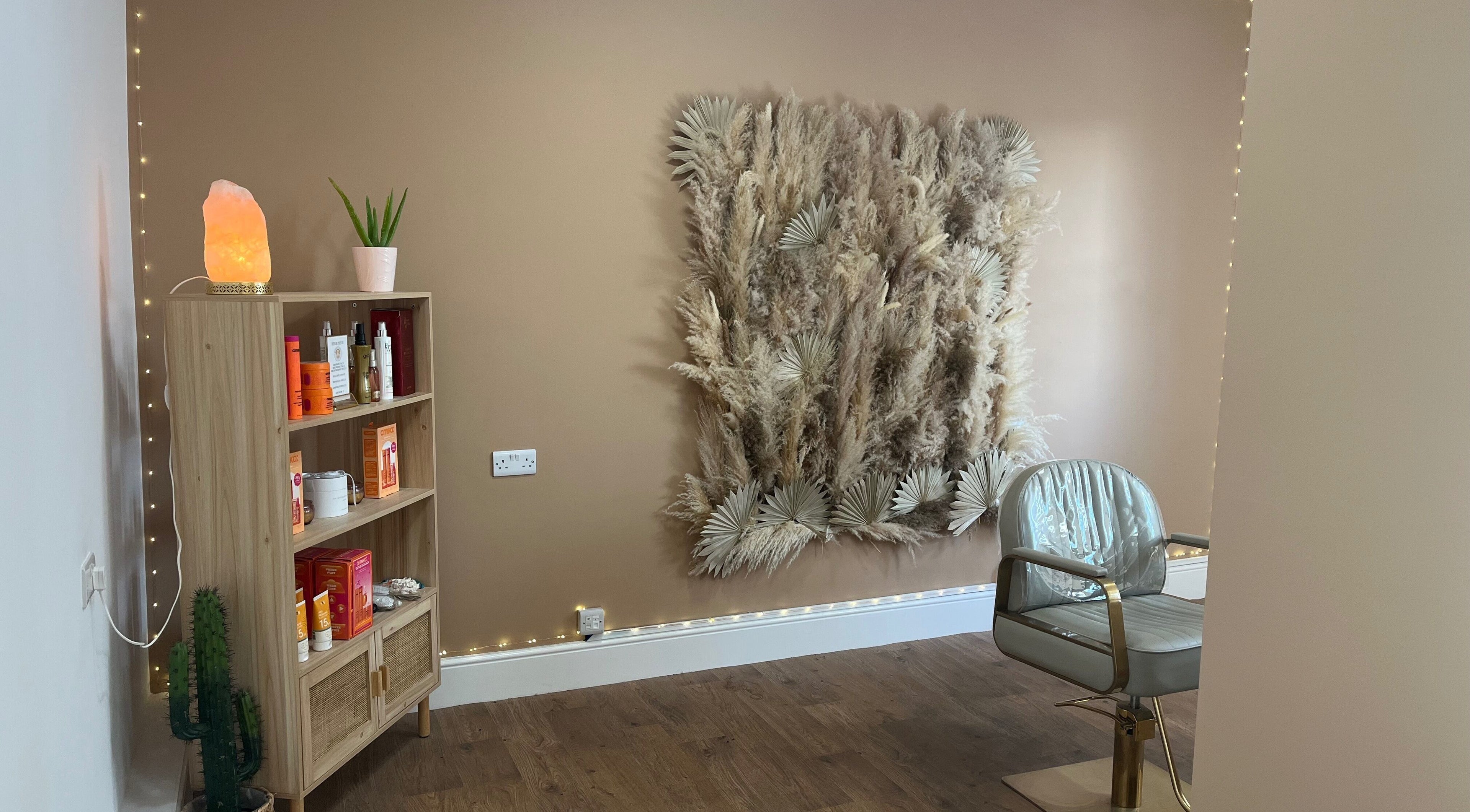 Serene salon corner at Goddess Rising Hair Extensions, Belper, England, GB featuring chic wall decor and a stylish chair.