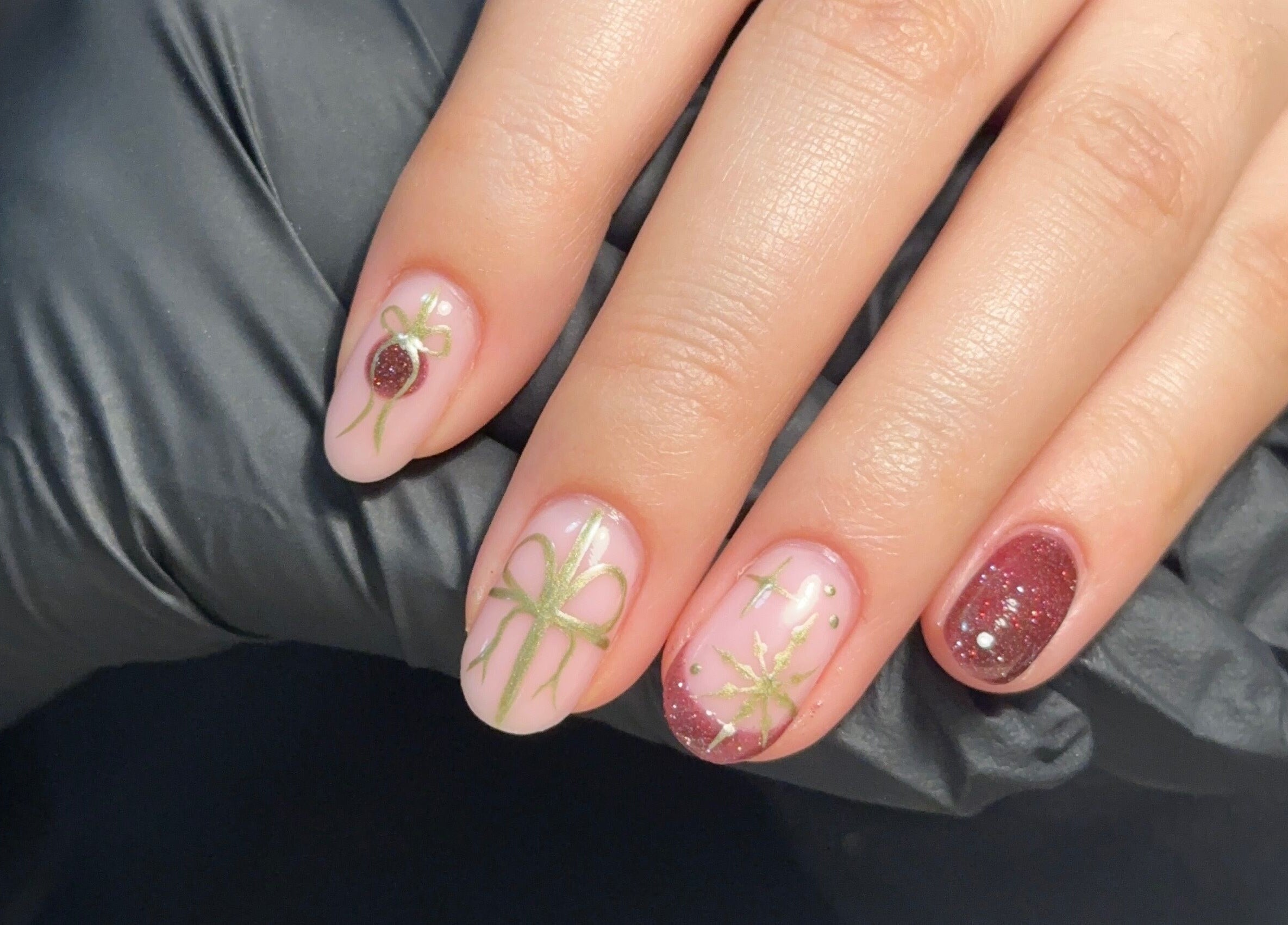 Beautiful festive nail art at Muse Beauty Studio, Port Talbot, Wales, GB, featuring intricate green and red designs.