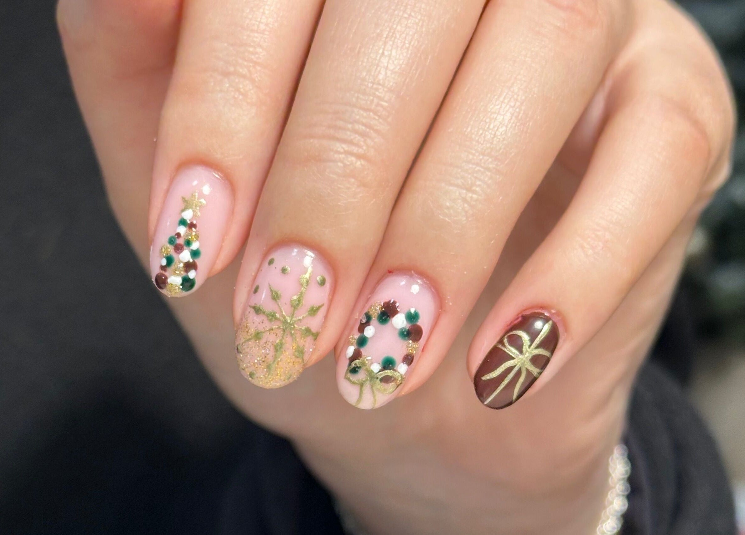 Festive nail art with gold and green accents at Muse Beauty Studio, Port Talbot, Wales, GB.