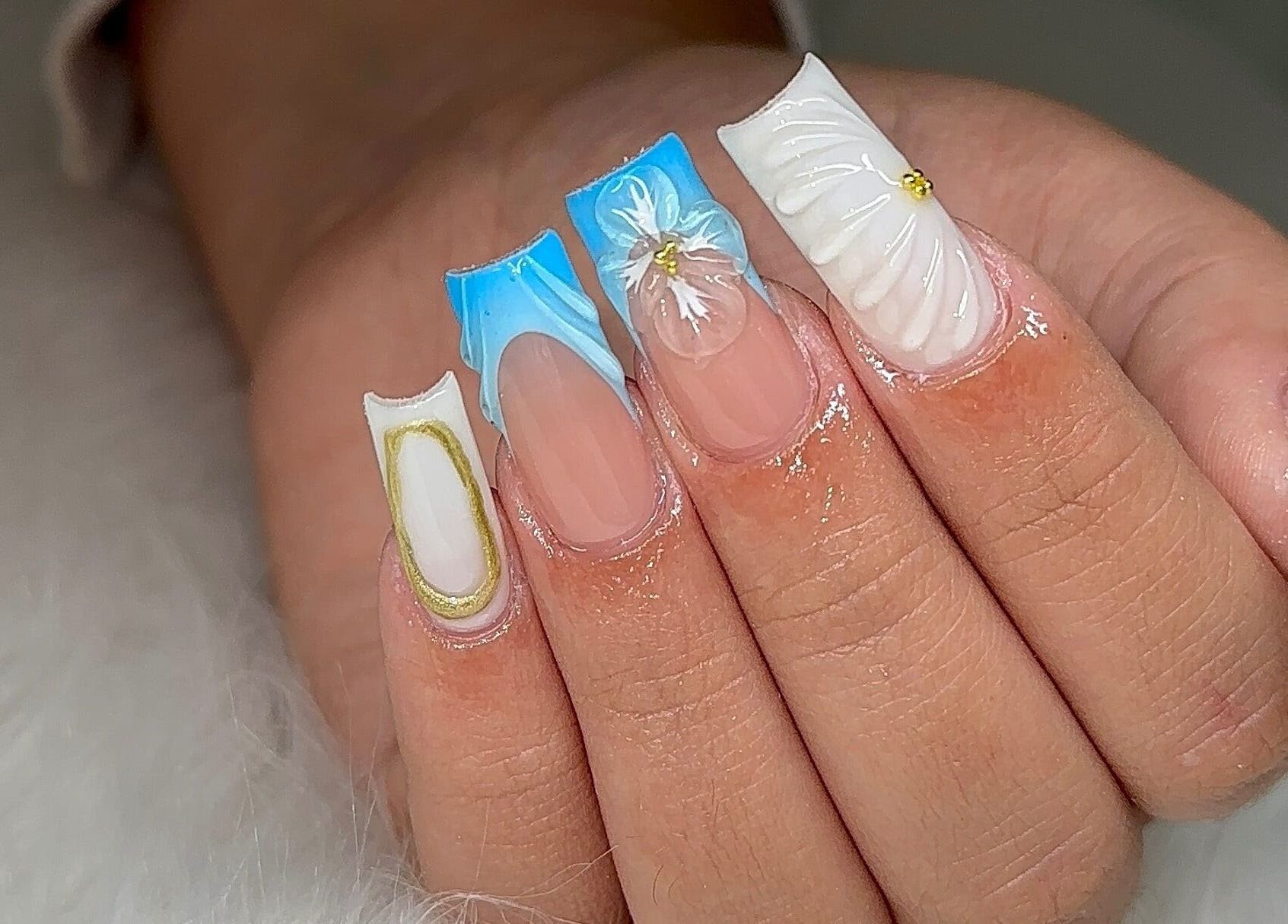 Elegant nail art at Fantasy Nails Miami, showcasing intricate blue and white designs, located in Miami, Florida, US.