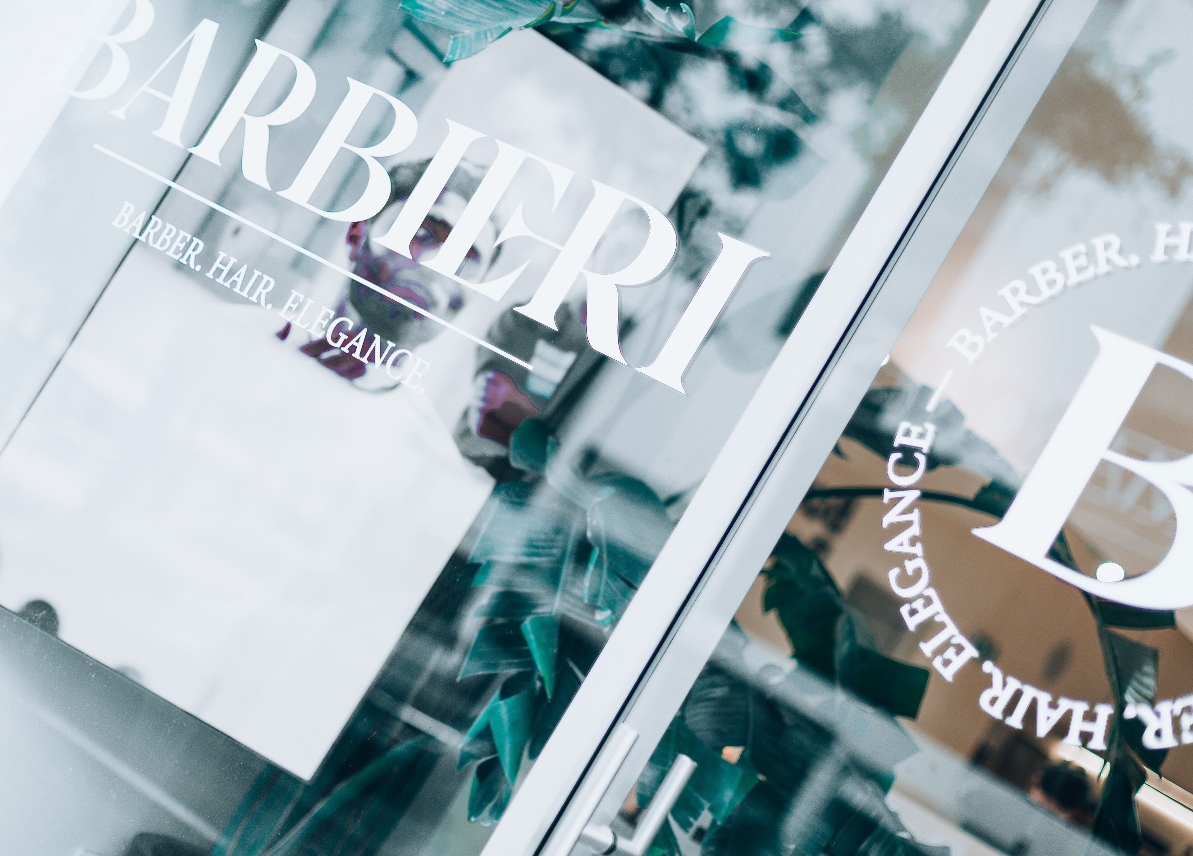 Entrance of Barbieri Barbershop & SPA in Lisboa, Lisboa, PT with stylish logo on glass door.