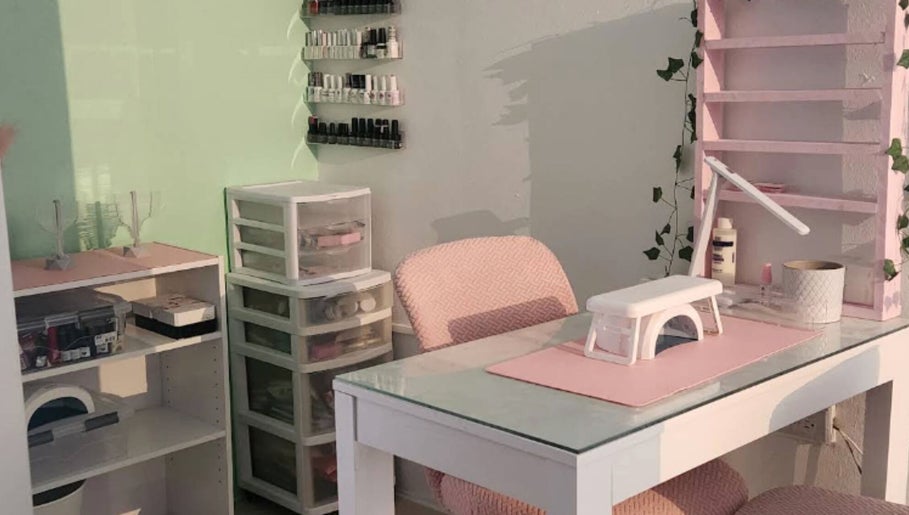 Mesa de manicura en Koquetinas Studio, Las Piedras, Las Piedras, PR, con sillas rosadas y organizadores de esmaltes.