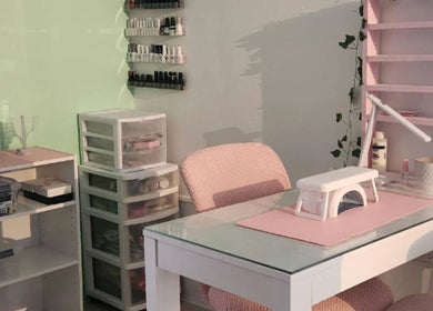 Mesa de manicura en Koquetinas Studio, Las Piedras, Las Piedras, PR, con sillas rosadas y organizadores de esmaltes.