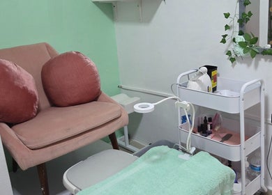 Espacio acogedor en Koquetinas Studio, Las Piedras, PR. Sillón rosado y carrito con productos de belleza.