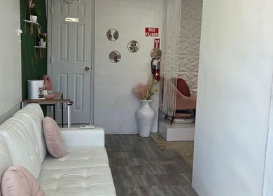 Área de espera con sofá blanco en Koquetinas Studio, Las Piedras, Las Piedras, PR, ideal para relajarse.