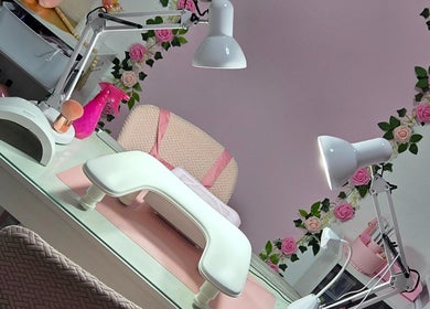 Área de trabajo elegante en Koquetinas Studio, Las Piedras, PR, decorada con temática rosa y lámparas modernas.