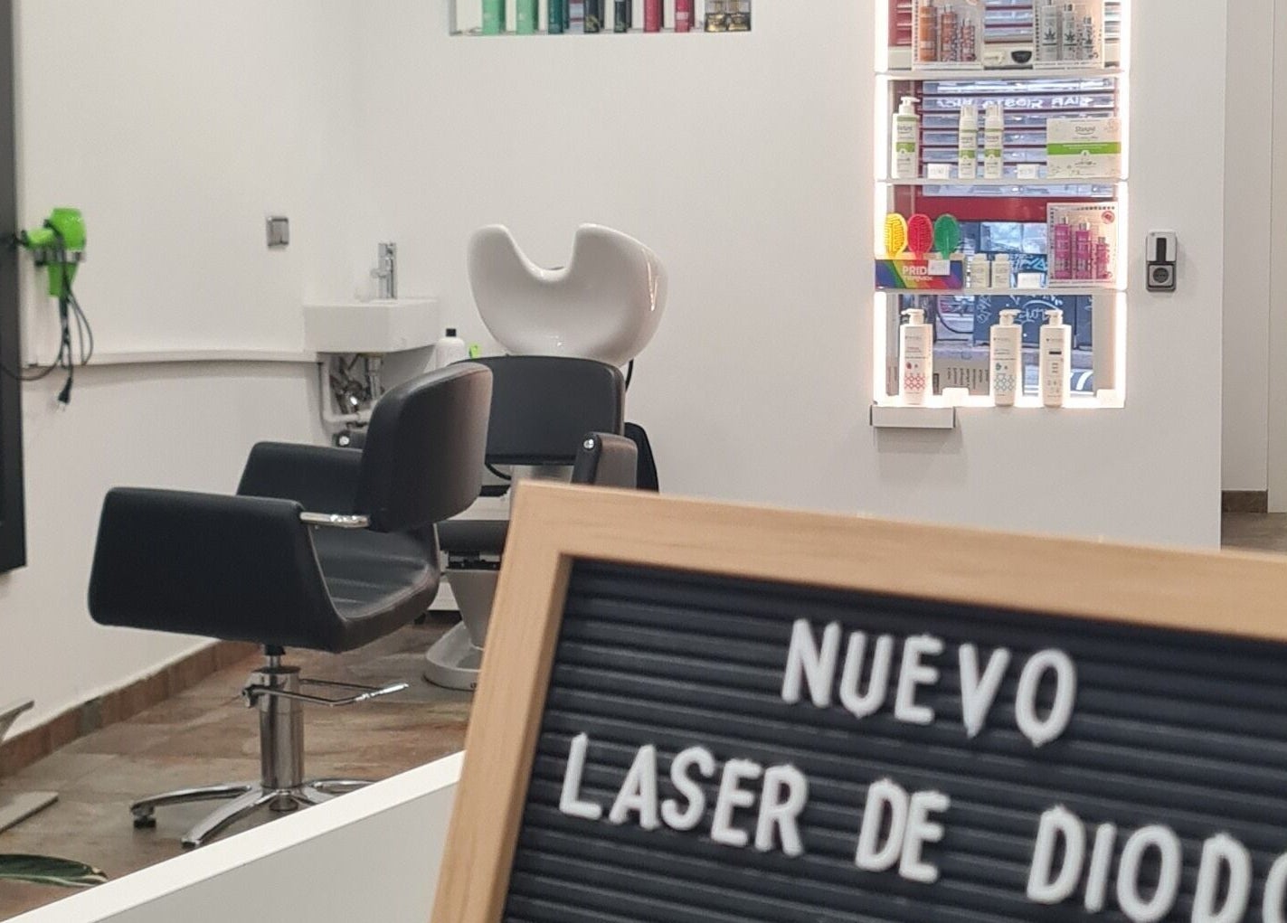 Interior moderno de Nuska, Barcelona, Catalunya, ES, con sillas de peluquería y productos de belleza.