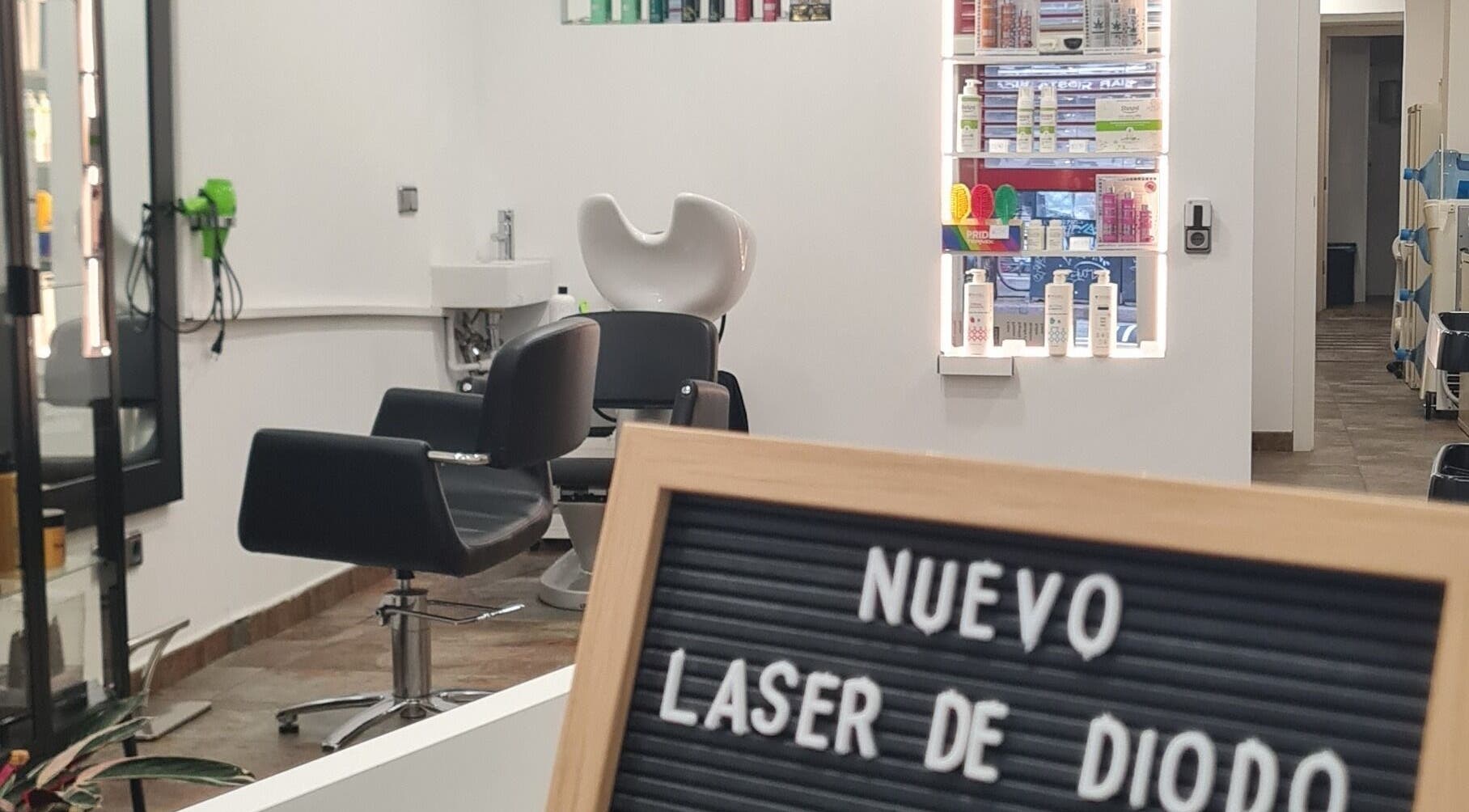 Interior moderno de Nuska, Barcelona, Catalunya, ES, con sillas de peluquería y productos de belleza.
