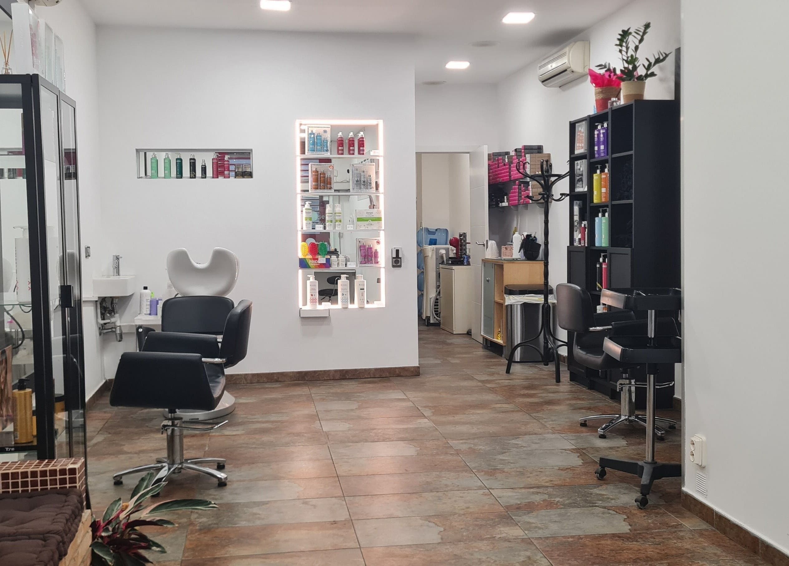 Elegante interior de Nuska en Barcelona, Catalunya, ES, mostrando sillas de peluquería y productos de belleza.