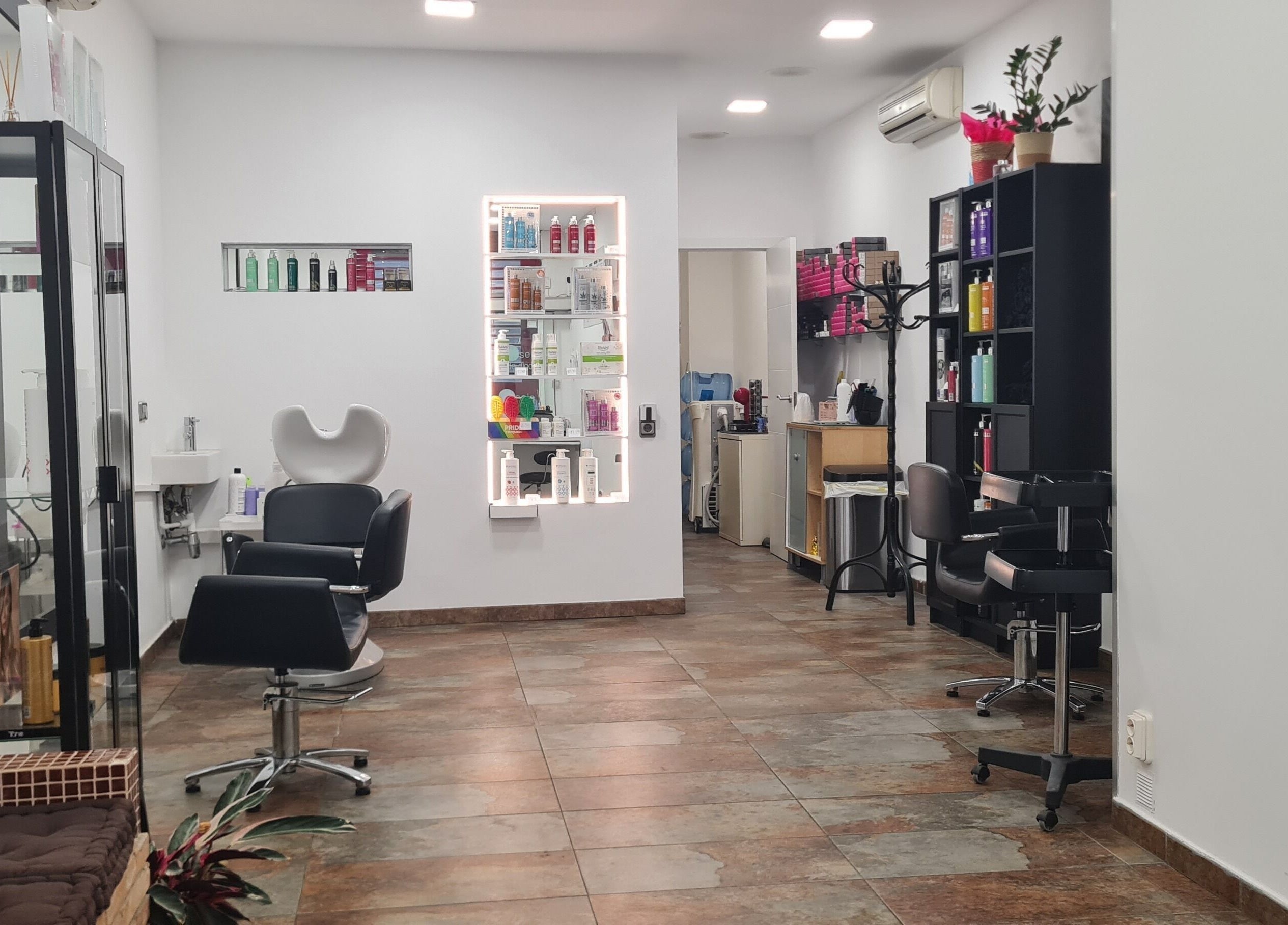 Elegante interior de Nuska en Barcelona, Catalunya, ES, mostrando sillas de peluquería y productos de belleza.