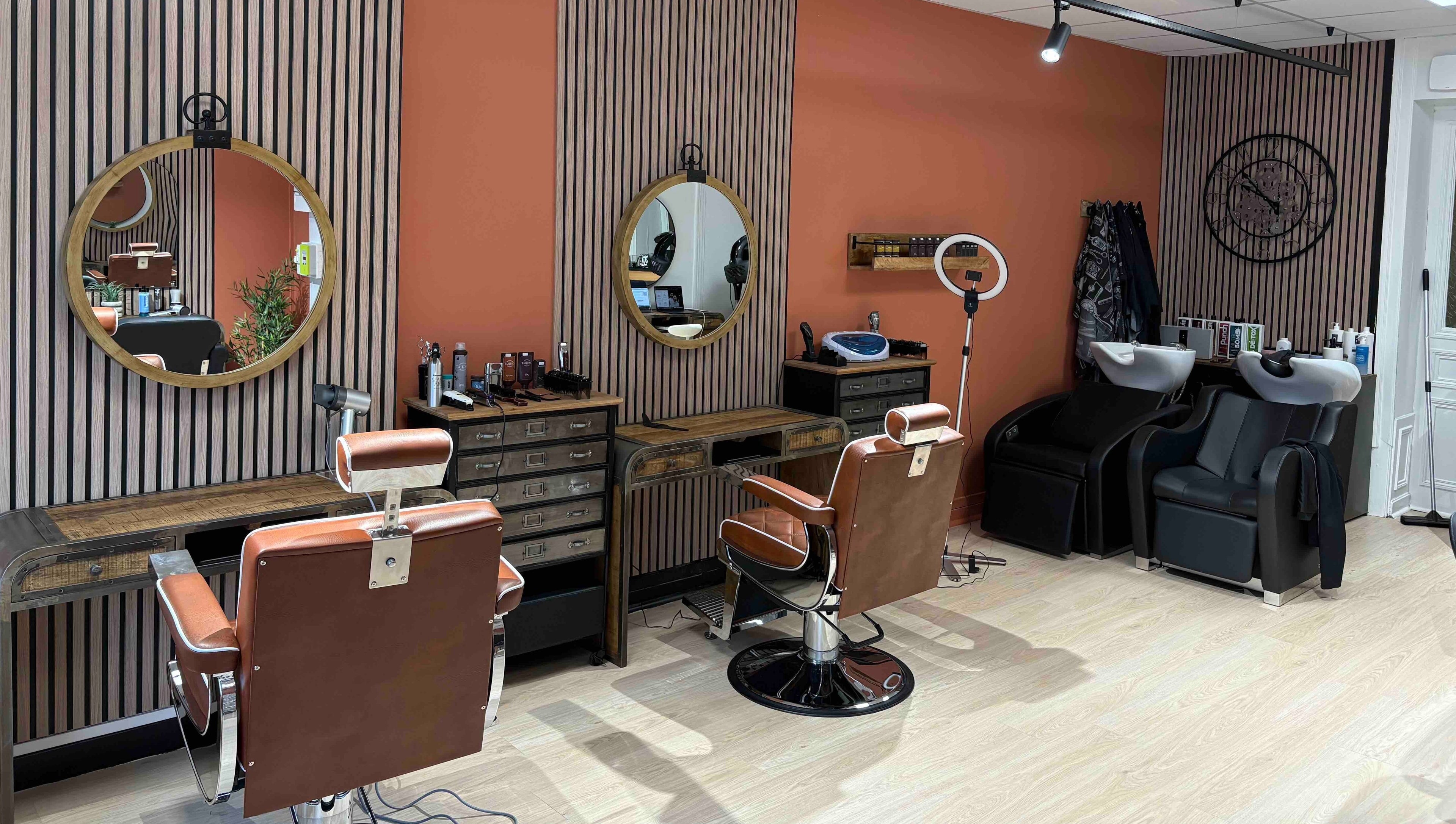 Salon Alexandre à Audruicq, Hauts-de-France, FR avec sièges en cuir et miroirs ronds élégants.