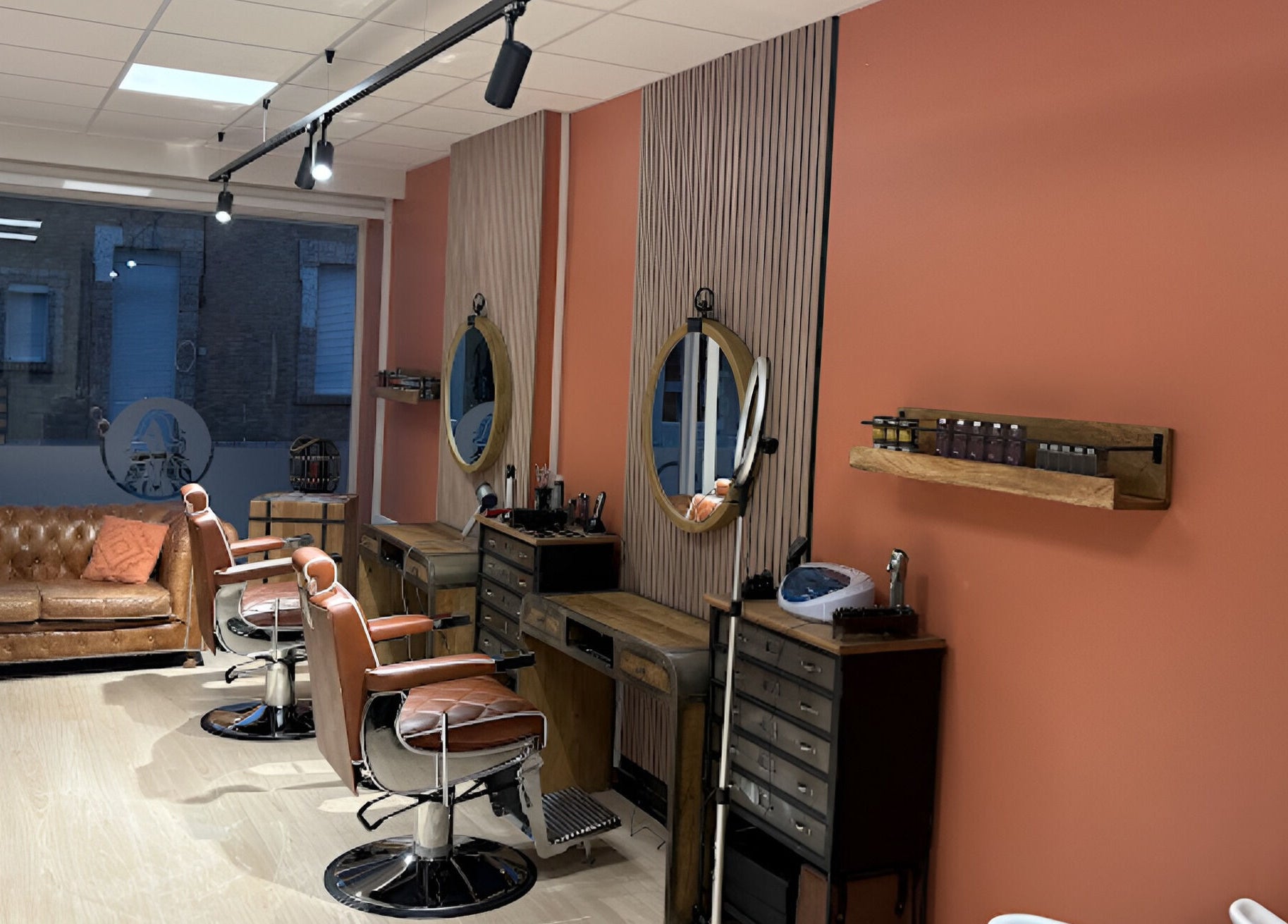 Intérieur élégant de Salon Alexandre à Audruicq, Hauts-de-France, FR, avec fauteuils en cuir et miroirs ronds.