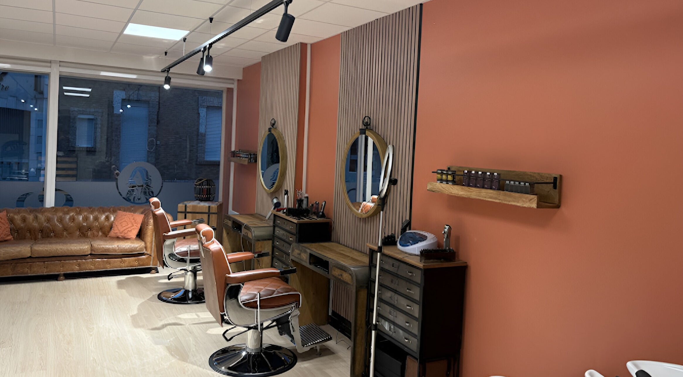 Intérieur élégant de Salon Alexandre à Audruicq, Hauts-de-France, FR, avec fauteuils en cuir et miroirs ronds.