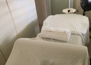 Camilla de masajes en Serenity Massage, Aguas Buenas, Aguas Buenas, PR con toallas blancas y ambiente relajante.