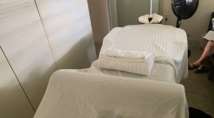 Camilla de masajes en Serenity Massage, Aguas Buenas, Aguas Buenas, PR con toallas blancas y ambiente relajante.