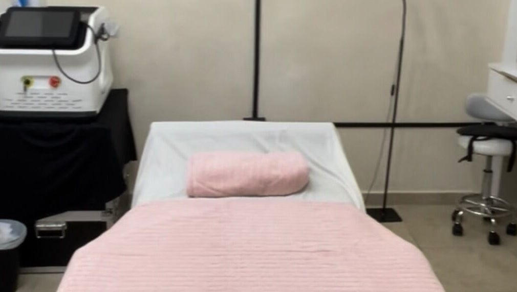 Camilla de masaje en Serenity Massage, Aguas Buenas, Aguas Buenas, PR con manta rosa y equipo de bienestar.