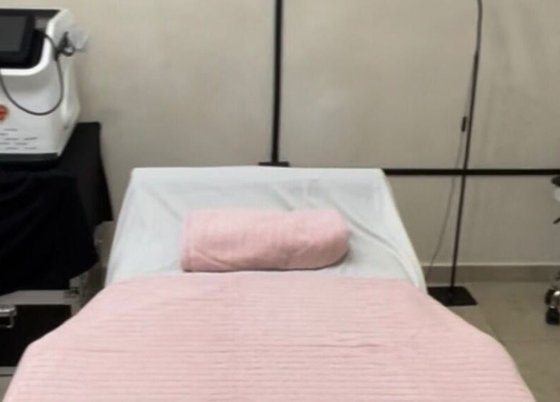 Camilla de masaje en Serenity Massage, Aguas Buenas, Aguas Buenas, PR con manta rosa y equipo de bienestar.