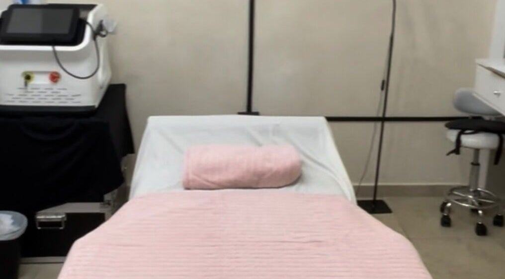 Camilla de masaje en Serenity Massage, Aguas Buenas, Aguas Buenas, PR con manta rosa y equipo de bienestar.