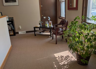 Inviting reception area at Crystal Pavis, LMT in Cromwell, Connecticut, US with plants and comfortable seating.