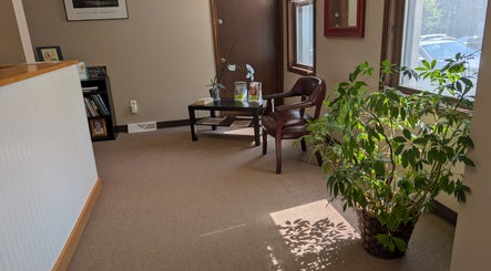 Inviting reception area at Crystal Pavis, LMT in Cromwell, Connecticut, US with plants and comfortable seating.