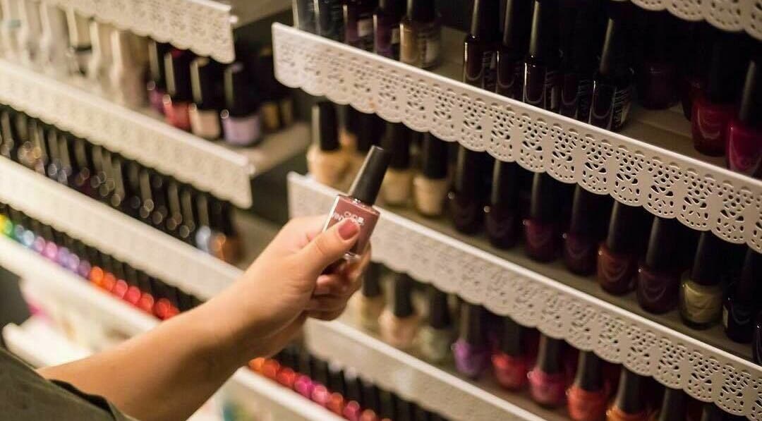 A hand selects nail polish at Paradise Spa and Coffee Bar, East Saint Paul, Manitoba, CA.