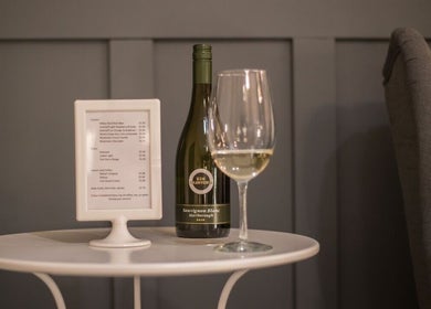Wine and glass on table at Paradise Spa Hair, East Saint Paul, Manitoba, CA, offering a cozy ambiance.