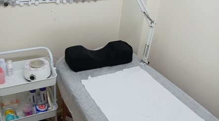 Sala de tratamiento en Adryana Studio, Santiago, Región Metropolitana, CL con cama y equipo profesional.