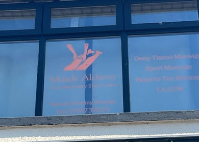 Front window of Muscle Alchemy Massage in Glengormley, Northern Ireland, GB showing services offered.