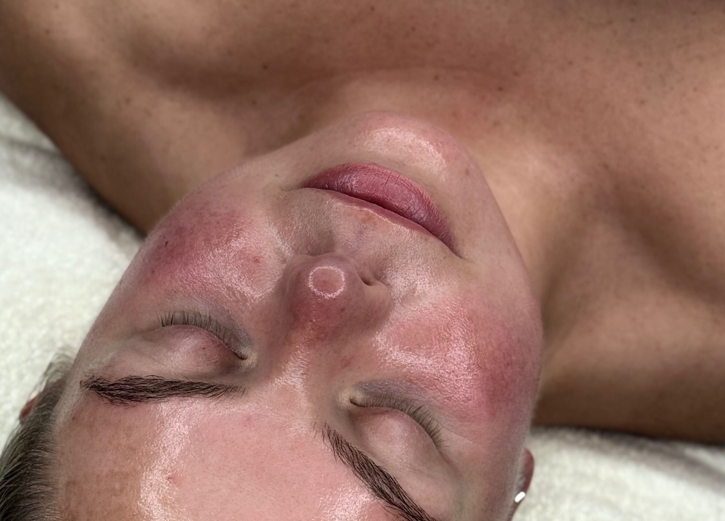 Relaxed client enjoying facial at The NUE Edit @ Fine Strokes, Chadderton, Oldham, England, GB.